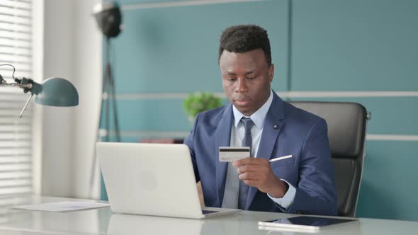 African Businessman Making Successful Online Payment on Laptop
