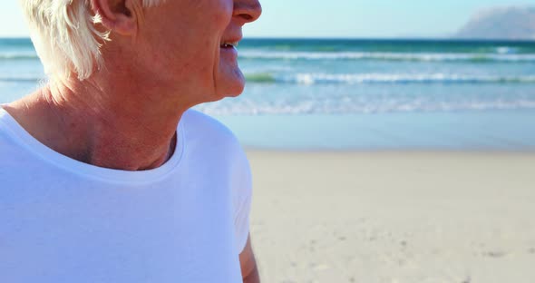 Smiling senior man standing on beach