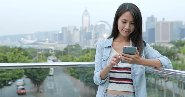 Woman using mobile phone in city 