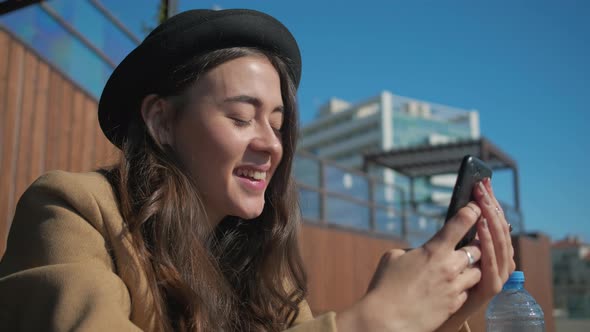 Happy Brunette Woman Reading Sms and Viewing Pictures in Smartphone, Close-up