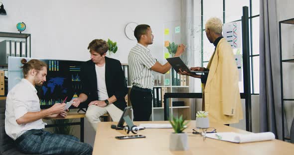 Male Colleagues Brainstorming Over Joint Business Strategy of Development Using Notes