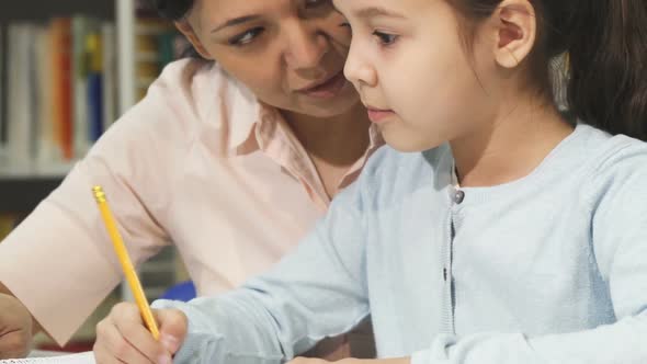 Cropped Shot of a Cute Little Girl Studying with Her Mother