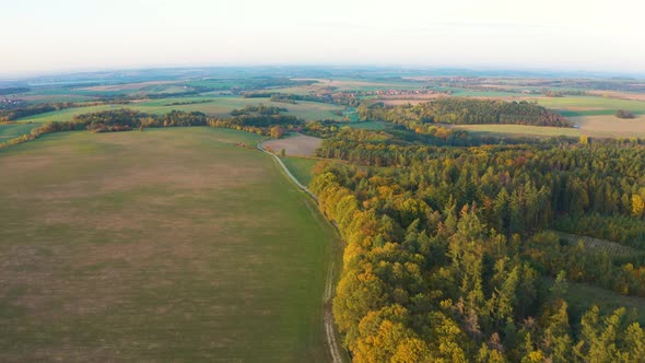 Aerial Drone Shot  a Rural Area with Forests Fields and a Road  Drone Flies Forward