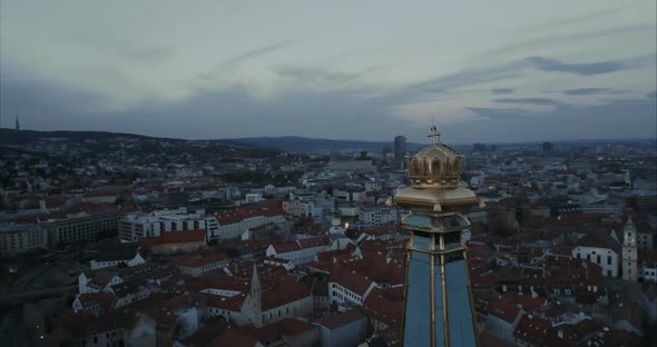 Close up shot of Crown on St. Martin Church in Bratislava at twilight with Castle in background, Aer