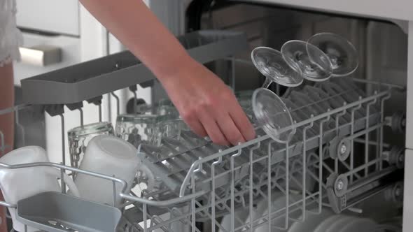 Female Hands Unloading Dishwasher at Home