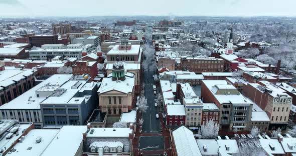 Lancaster PA aerial reveal shot during winter snow. Courthouse church steeples downtown commercial b