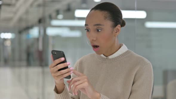 Creative African Woman Celebrating on Smartphone