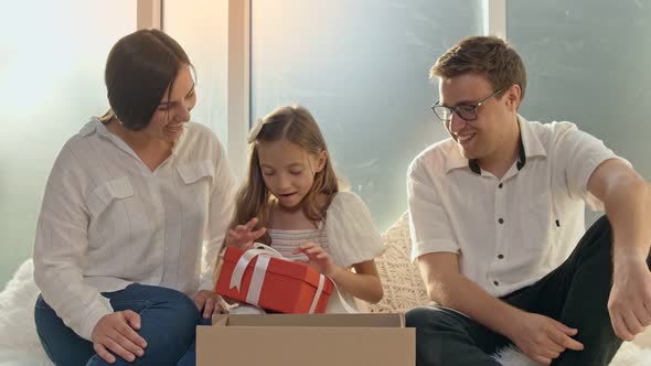 Adorable Girl Unpacking the Order. Happy Family Unpacking the Order