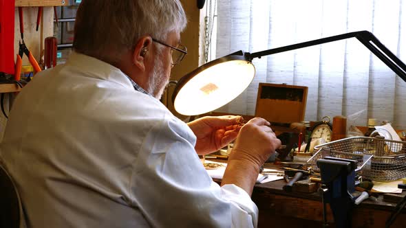 Rear view of horologist repairing a watch