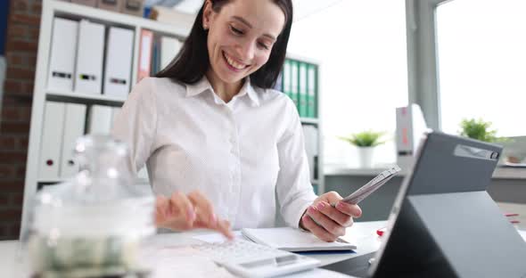 Happy Successful Businesswoman Counts Cash at Workplace Closeup