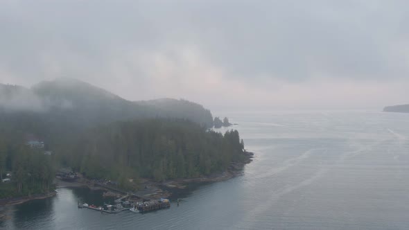 Aerial View of a small secluded town on the Pacific Ocean Coast during a cloudy summer sunrise. Take