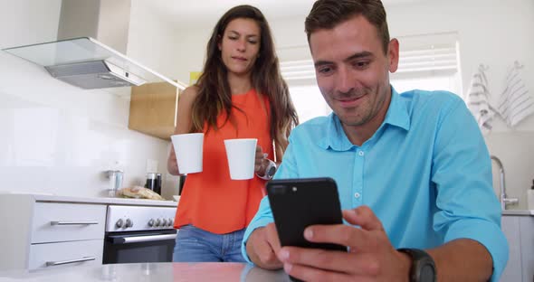 Young woman serving coffee to man on dining table in kitchen at home 4k