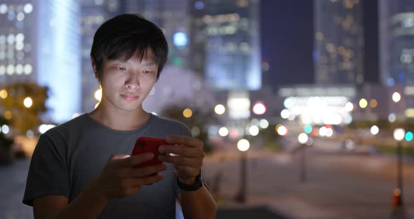 Asian man use of mobile phone in city at night