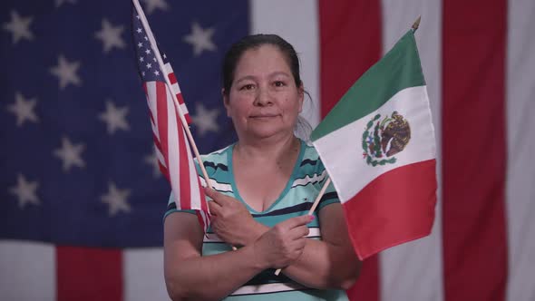 Woman holding up American Flag and Flag of Mexico