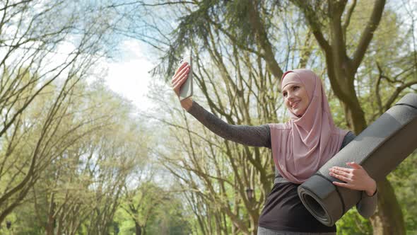 Happy Muslim Woman in Sport Outfit and Hijab Taking Selfie on Modern Smartphone