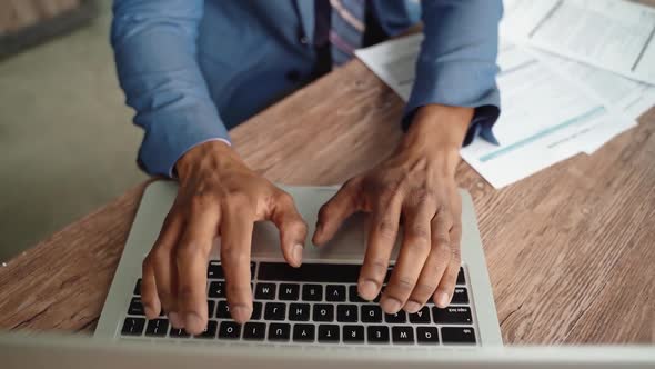 African American businessman working on his laptop, finance concept with unrecognizable male in suit