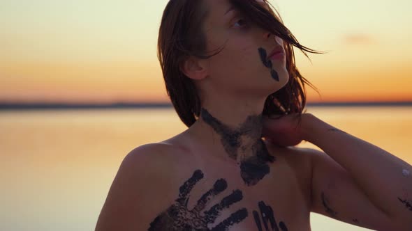 Attractive Body Painted Emotive Caucasian Female at a Salt Lake in Slow Motion