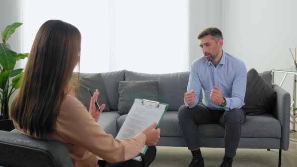 Man Patient with Mental Health Problems Talking to Therapist and Breathes Deeply