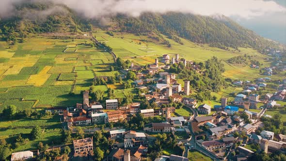 Aerial drone view of a village in Georgia. Valley, buildings, mountains and hills slopes covered wit