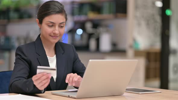 Indian Businesswoman Making Successful Online Payment on Laptop in Office 