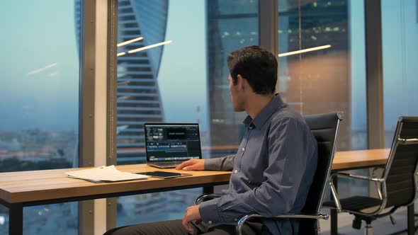 Hispanic Employee Male Sitting in Armchair with Laptop in Business Office