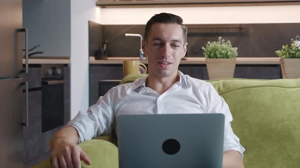 Young Man Using Video Chat on Laptop Computer To Communicate with Friends or Business Partners