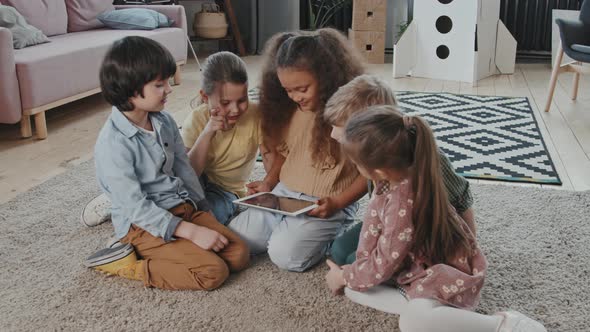 Children Sitting on Floor and Using Tablet