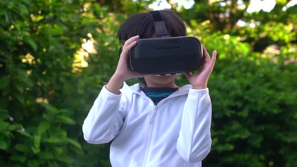 Asian Child With Virtual Reality Headset Touching Outdoors