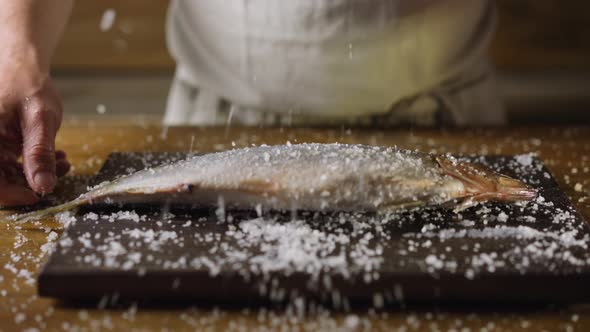 Chef Throws Fat Pickled Herring Into Salt Pile on Board