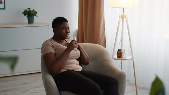 Overweight Black Woman Choking Drinking Water From Glass At Home