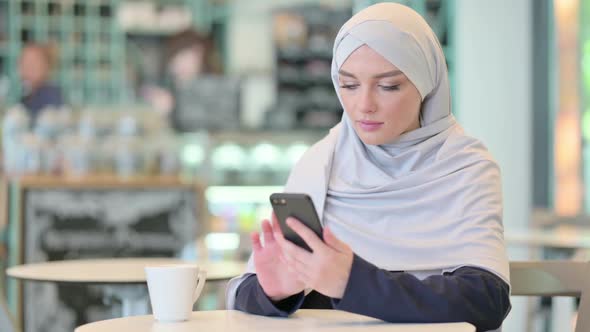 Serious Young Arab Woman Using Smartphone