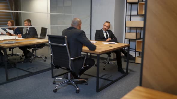 Two Diverse Businessmen Discussing Planning Talking During Evening Briefing at Modern Boardroom