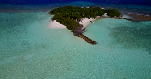 Wide angle drone abstract shot of a white sandy paradise beach and blue water background in vibrant 