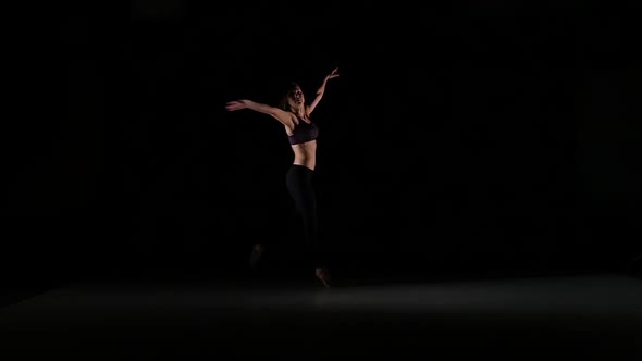 Sporty Girl Dancing Contemporary in the Shadow on Black Background, Slow Motion