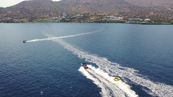 Aerial View of a Motor Boat Towing a Tube. Elounda, Crete, Greece