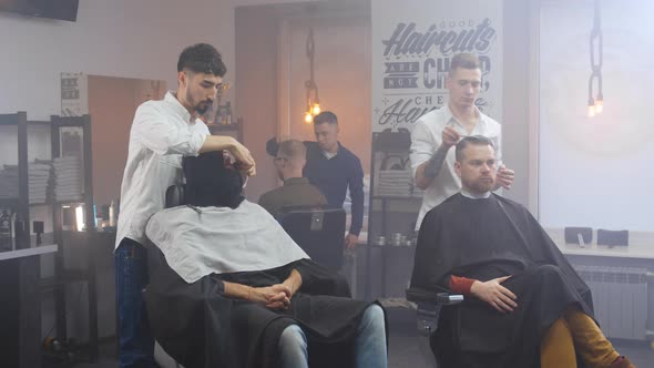 Barbershop Room with Clients in Chairs and Hairdressers Working