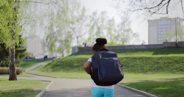 Schoolgirl with a Backpack Runs Home in the Park From Her School Dream on a Sunny Day