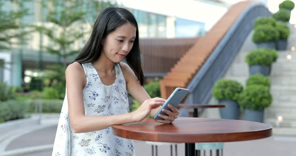 Woman using cellphone at outdoor cafe