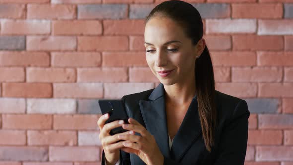 Smiling Businesswoman with Ponytail Using Smartphone