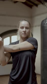 Vertical Shot of Female Boxer Stretching Arms Before Workout