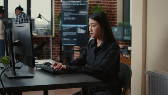 System Engineer Focused on Writing Code Sitting at Desk in Software Development Office