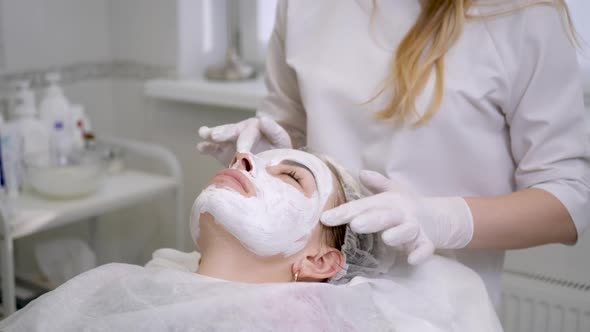 Doctor Cosmetologist in Rubber Gloves Apply Cream on the Face