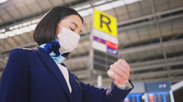 Airliner air hostess crew wearing face mask walking in airport terminal to the airplane during Covid