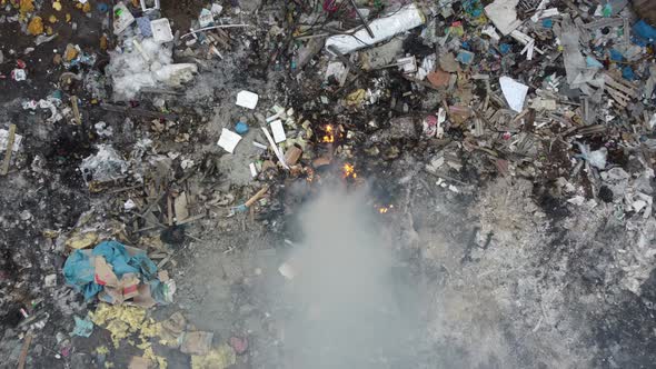 Aerial descending look down open burning of rubbish