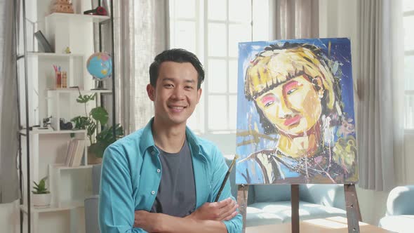 Artist Man Holding Paintbrush Mixed Colour, Crossing His Arm, And Smiling After Finish Painting