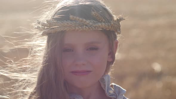 Serious Sad Girl a Child Stands on a Wheat Mown Field