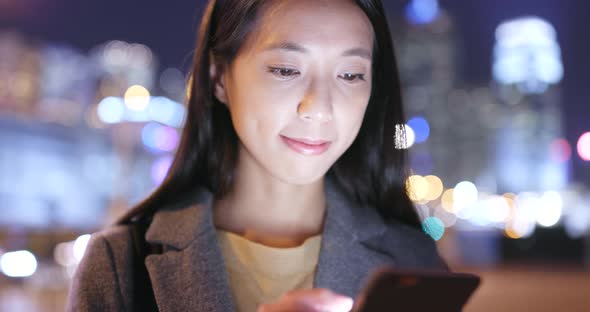 Young Woman use of mobile phone in Hong Kong at night