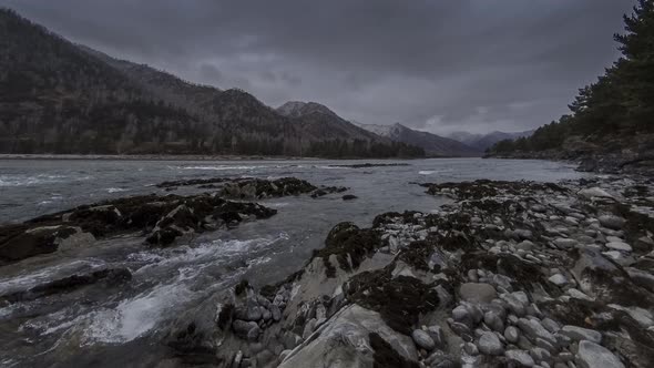 Time Lapse Shot of a River Near Mountain Forest. Huge Rocks and Fast Clouds Movenings