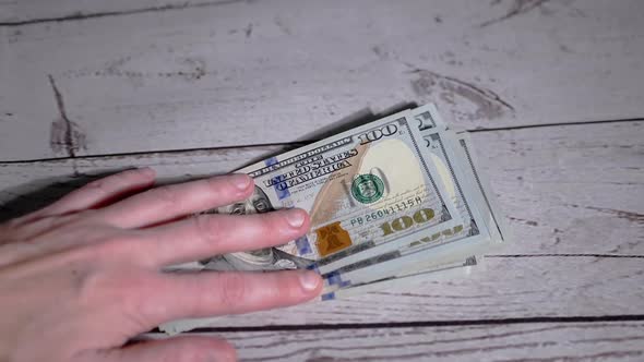 Female Hands Laying Out a Stack of 100 Dollar Bills Counting Money