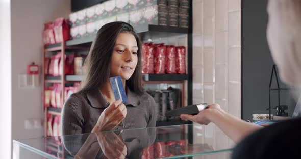 the Beautiful Young Lady Pays with the Card in the Cafe Contactless Payment